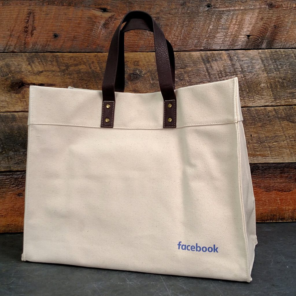 • 24oz, Natural Canvas Tote Bag 
• Vegan leather handles 
• Interior hanging pocket with zippered compartment 
• Size: 20” W X 13” H X 6” D
• Facebook wordmark on lower front