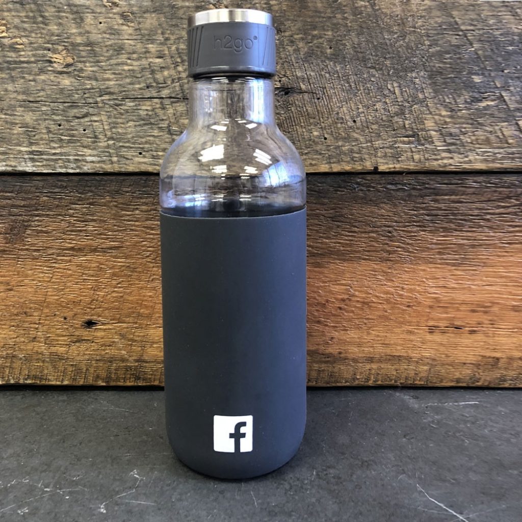 • 25 oz single wall [BPA-free] Eastman TritanTM copolyester bottle 
• Threaded PP lid, stainless steel accent, and silicone sleeve  
• Facebook favicon in white